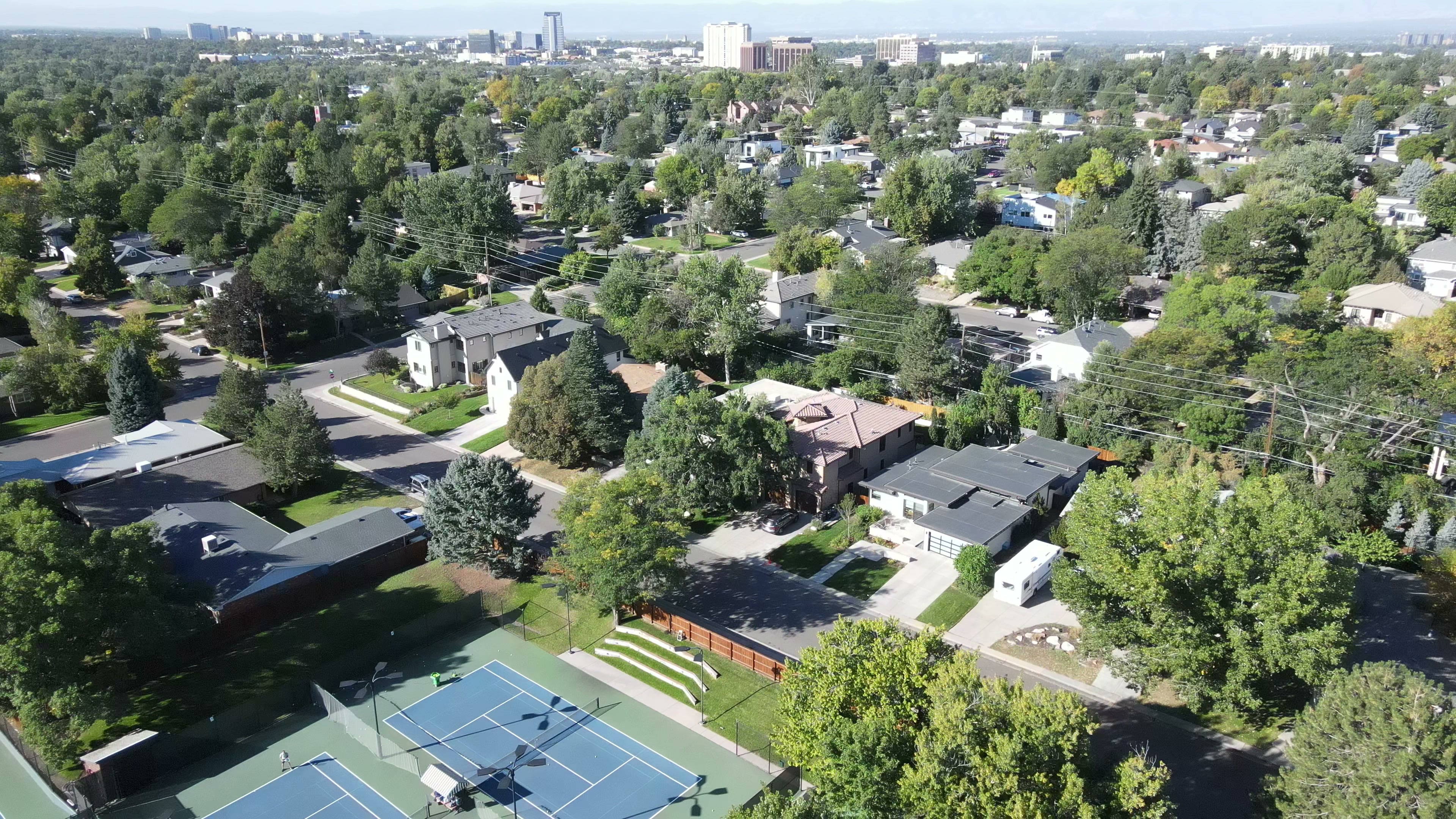 Aerial view of Denver's Hilltop neighborhood with the Crestmoor Community Association courts, mature tree canopy, and downtown skyline