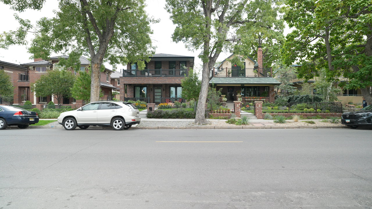 Modern brick home and Craftsman-style home side by side on a tree-lined Wash Park street in Denver